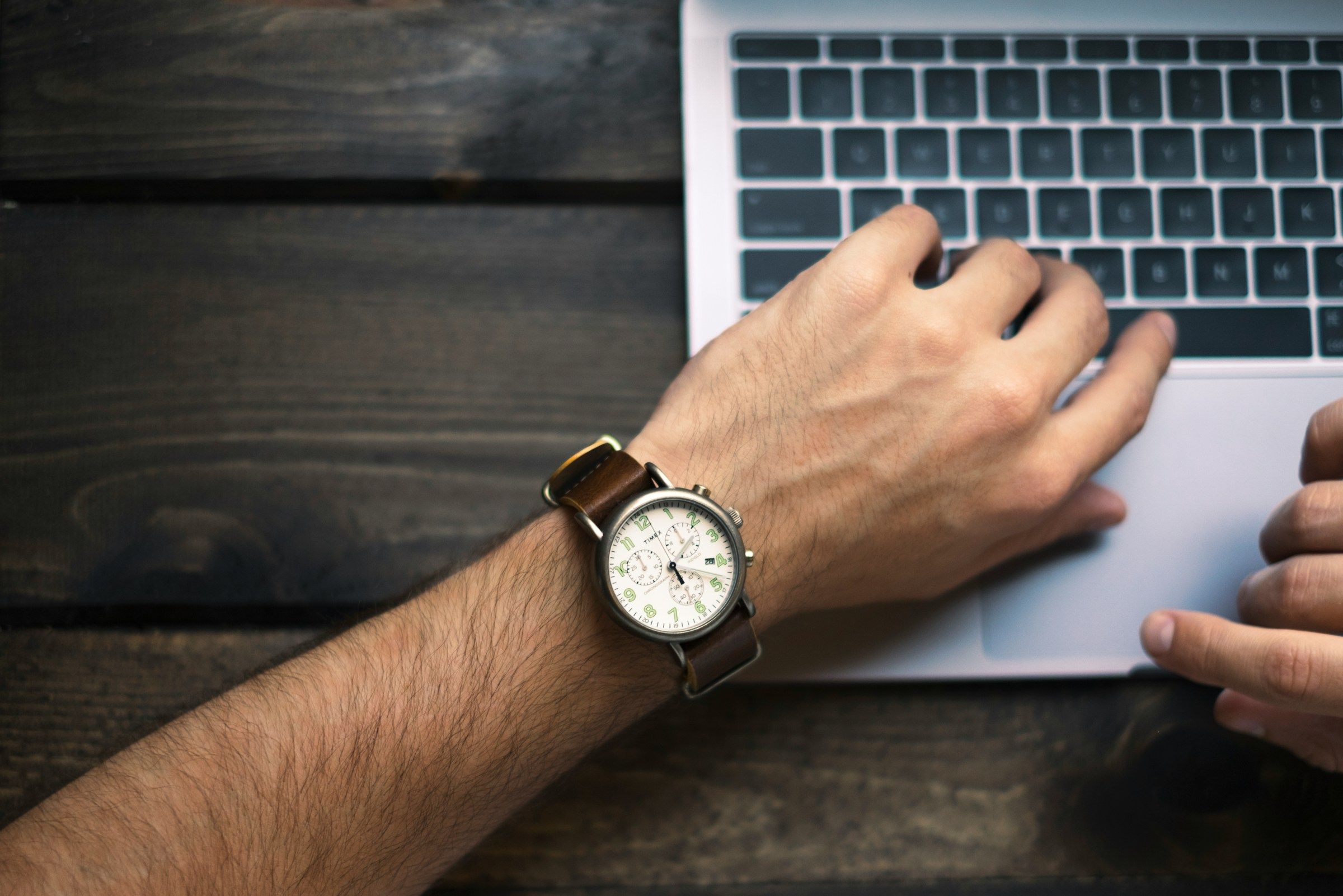 man looking at his watch - How Long Does It Take to Onboard a New Employee