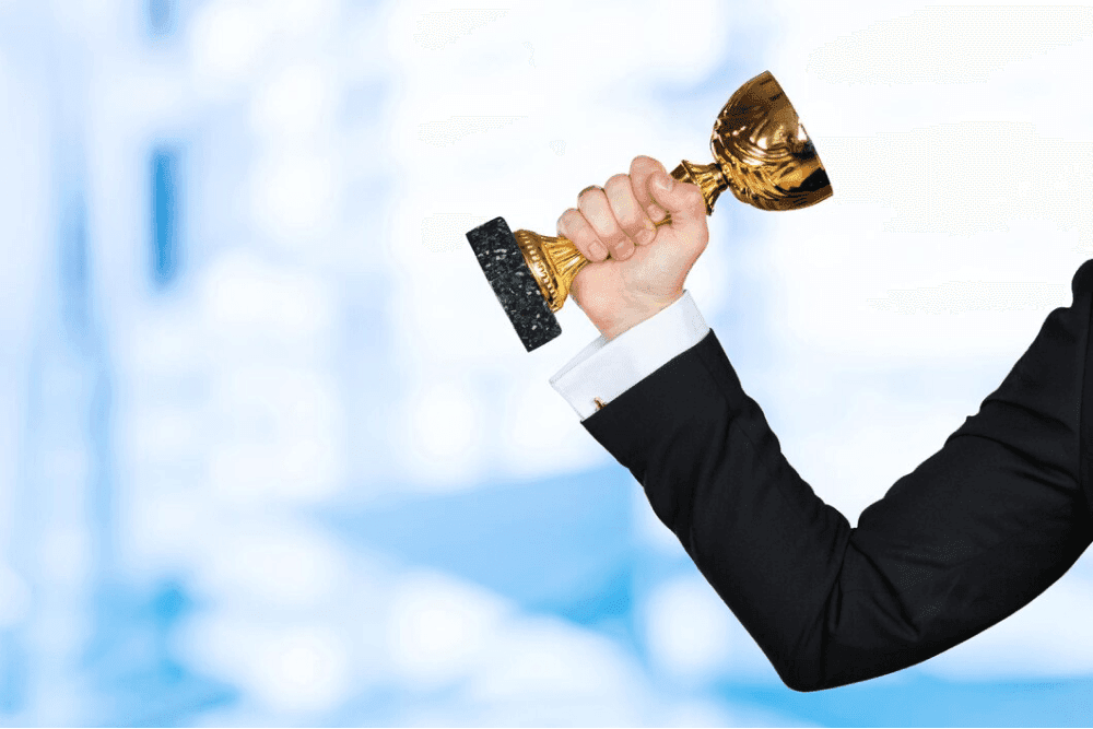 businessman holding trophy
