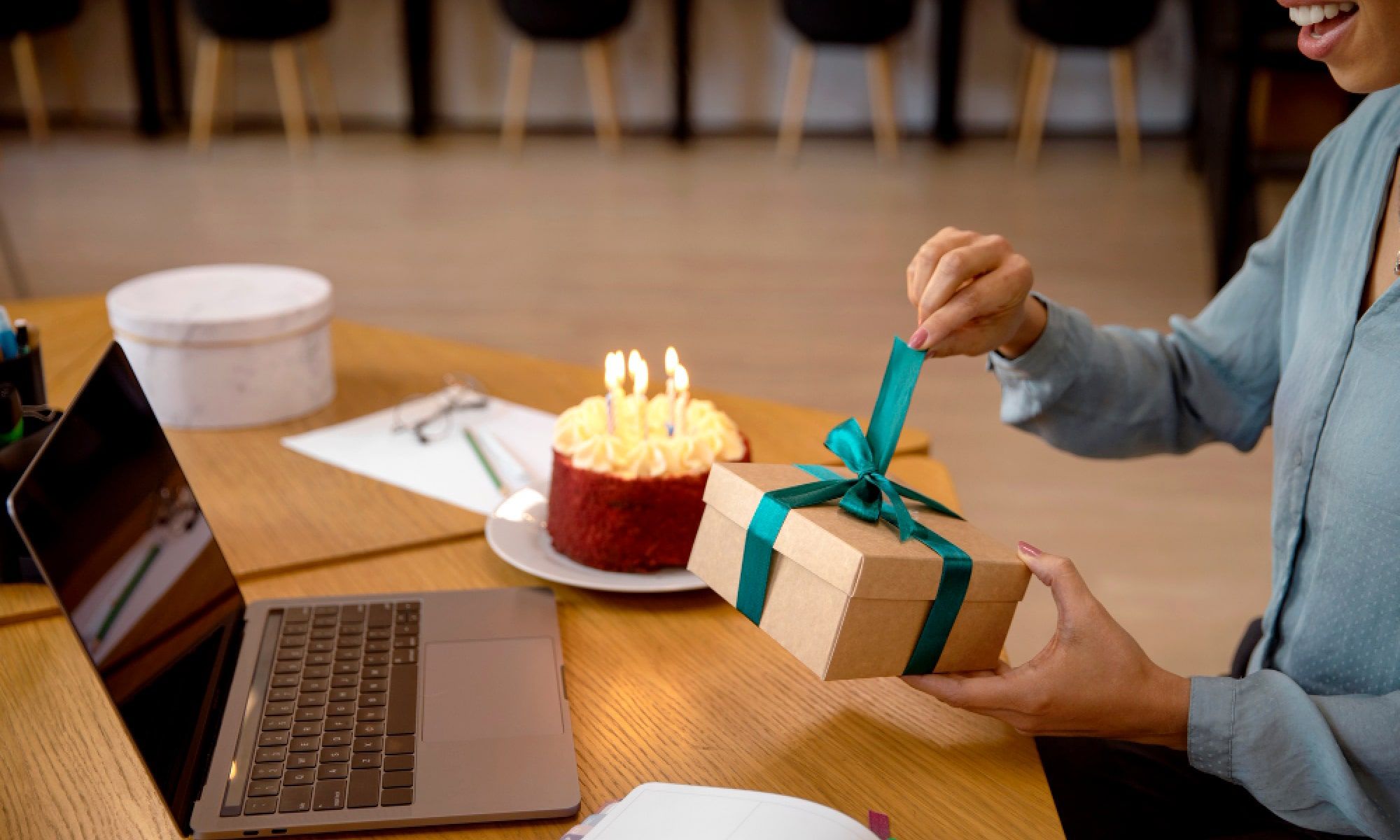woman unwrapping corporate gifts - Team Holiday Gifts