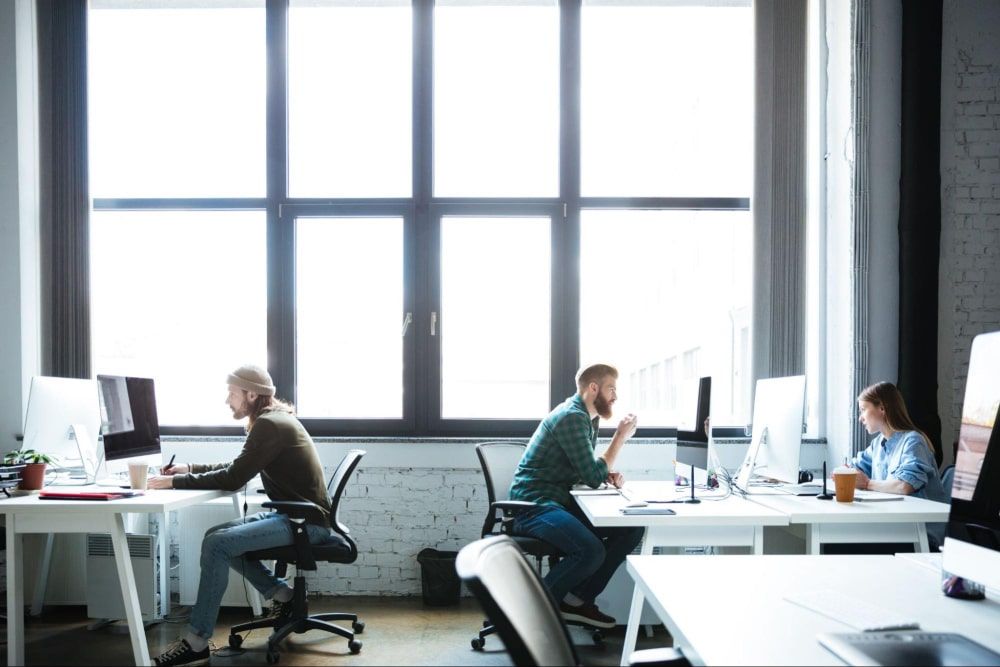 a corporate setting of employees working - Employee Engagement Measurement